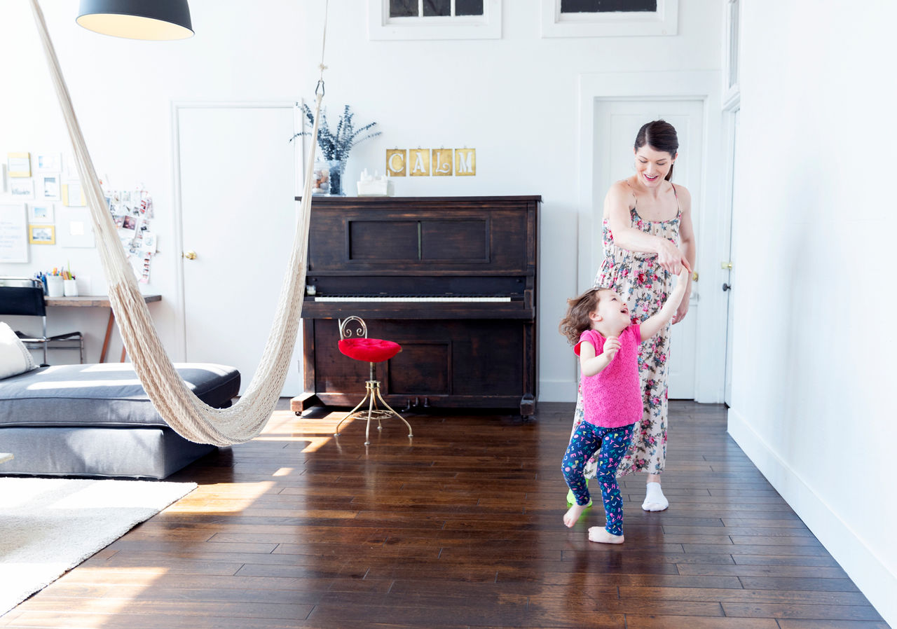 Frau und Kind tanzen im Wohnzimmer
