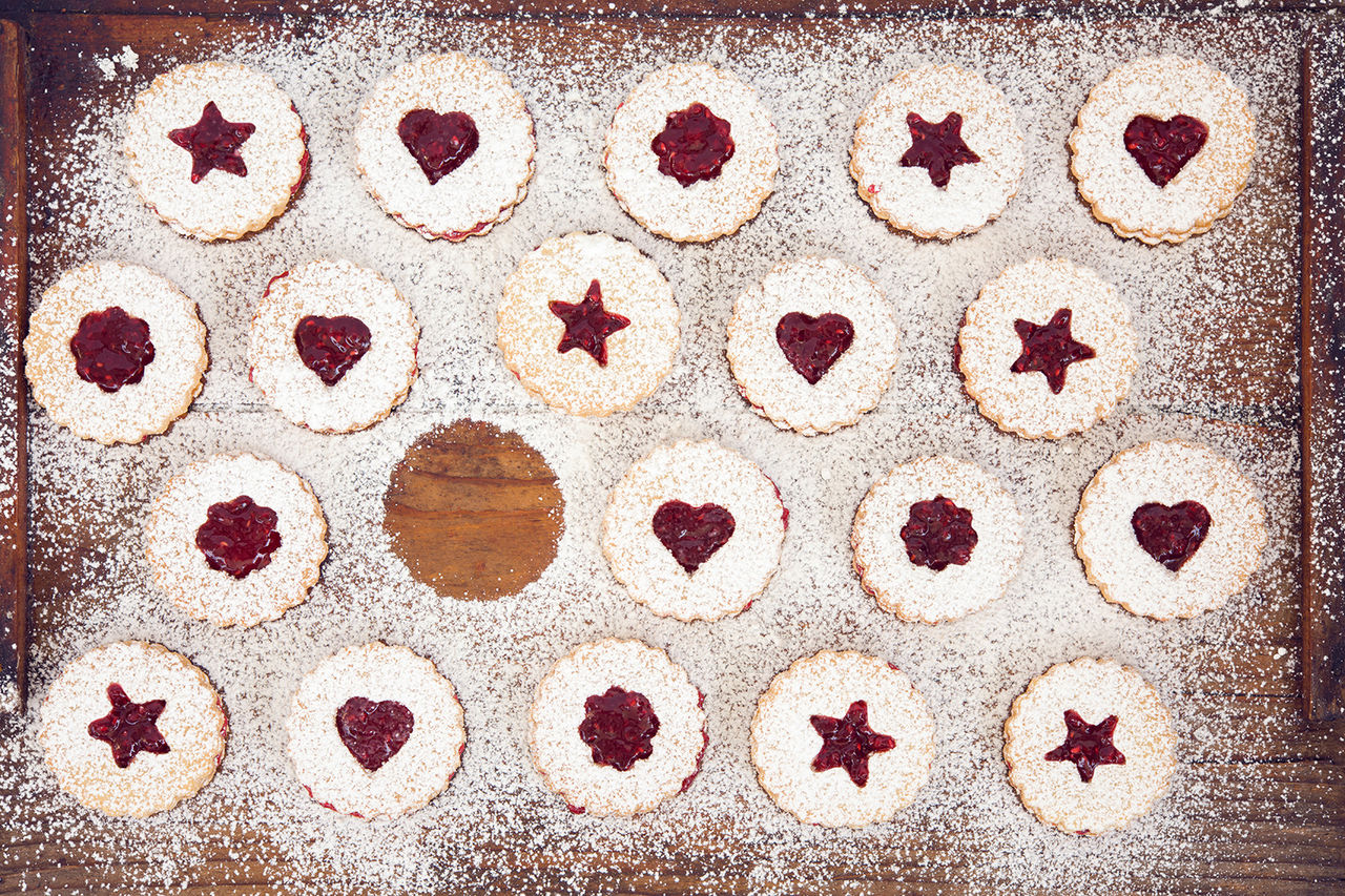 Linzer Christmas cookies with jam and powder sugar flat lay and copy space. Creative concept.