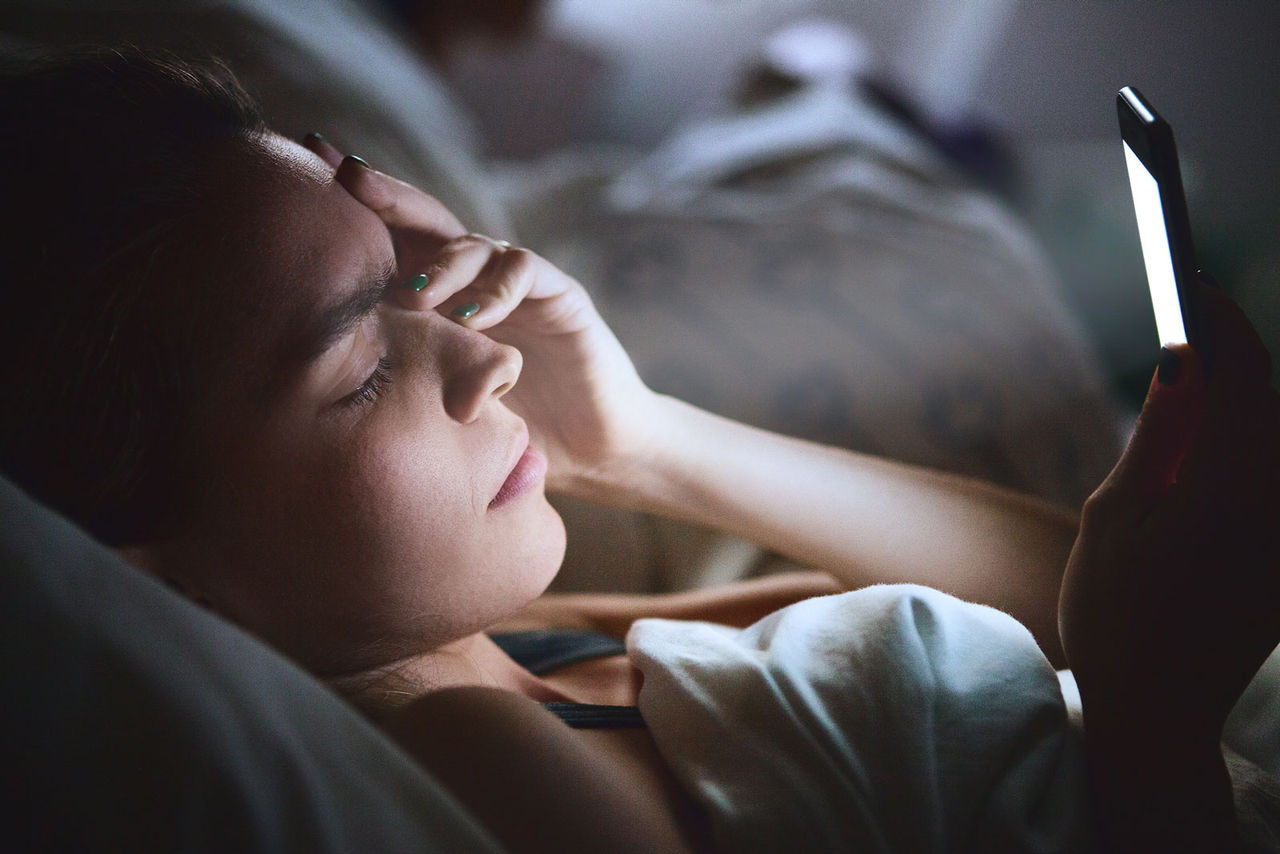 Hände weg vom Smartphone: Das blaue Licht vom Display lässt uns oft schlechter schlafen.