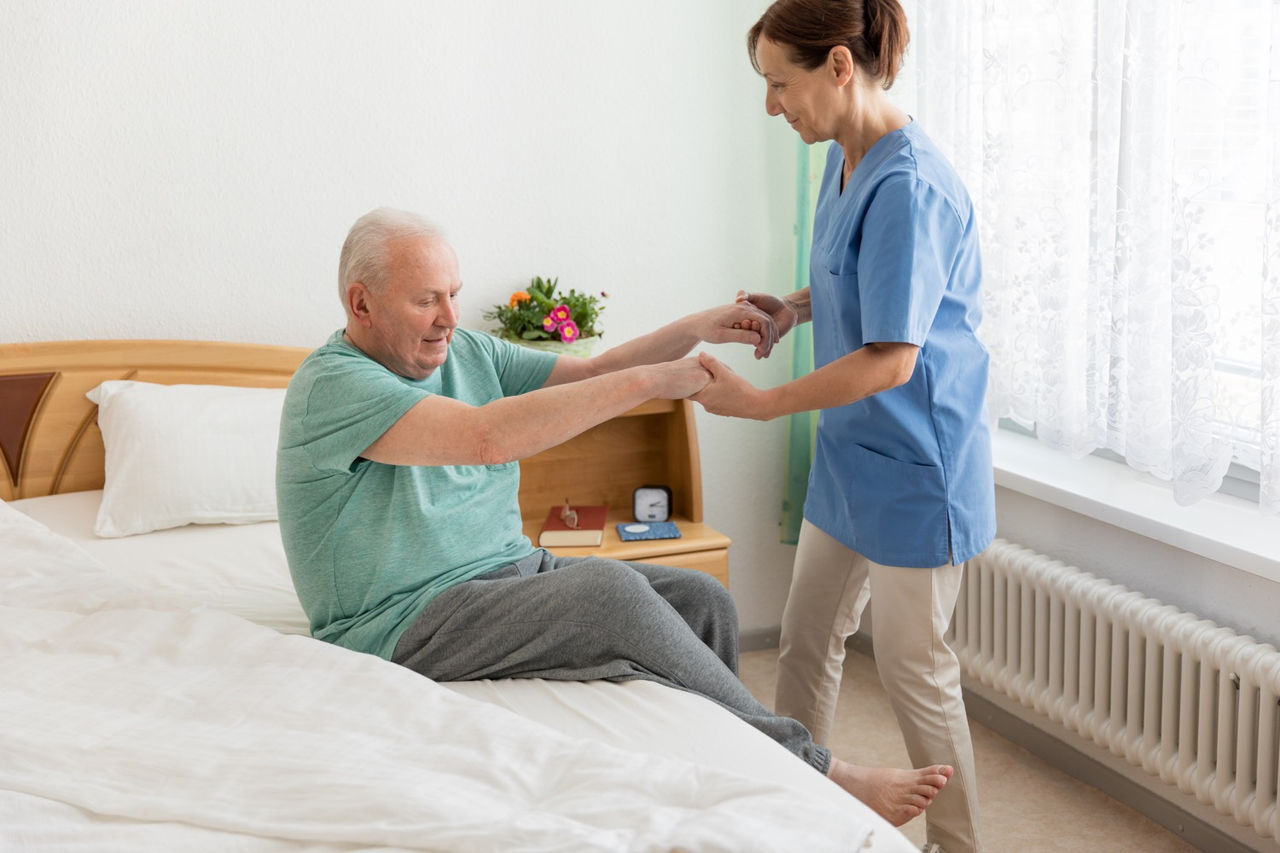 Female caregiver helping senior man