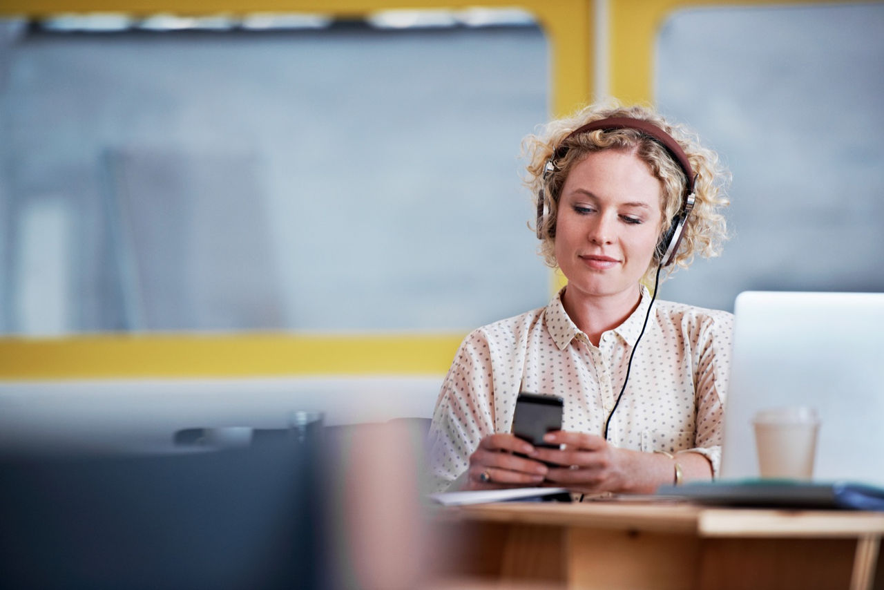 Shot of a designer listening to music while texting at her deskhttp://195.154.178.81/DATA/i_collage/pu/shoots/804606.jpg