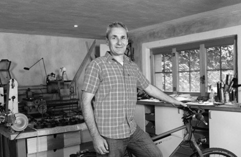 Mann mit Fahrrad in einer Werkstatt