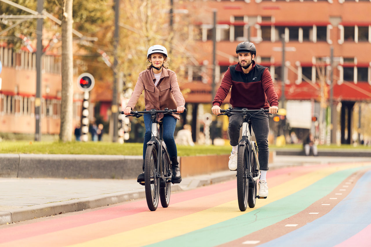 Zwei Personen fahren nebeneinander Fahrrad auf einem Fahrradweg