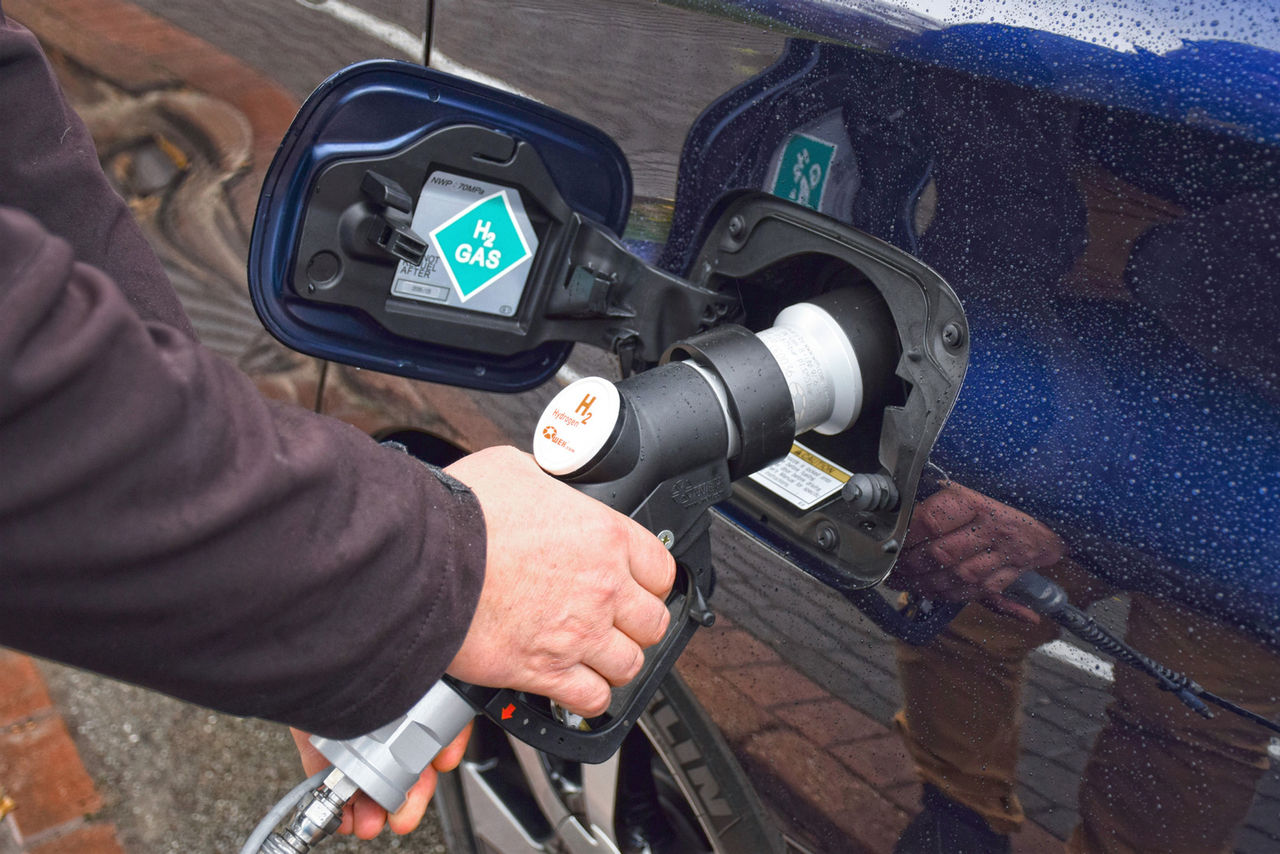 Ein Wasserstoffauto wird an einer Wasserstoff-Tankstelle betankt.